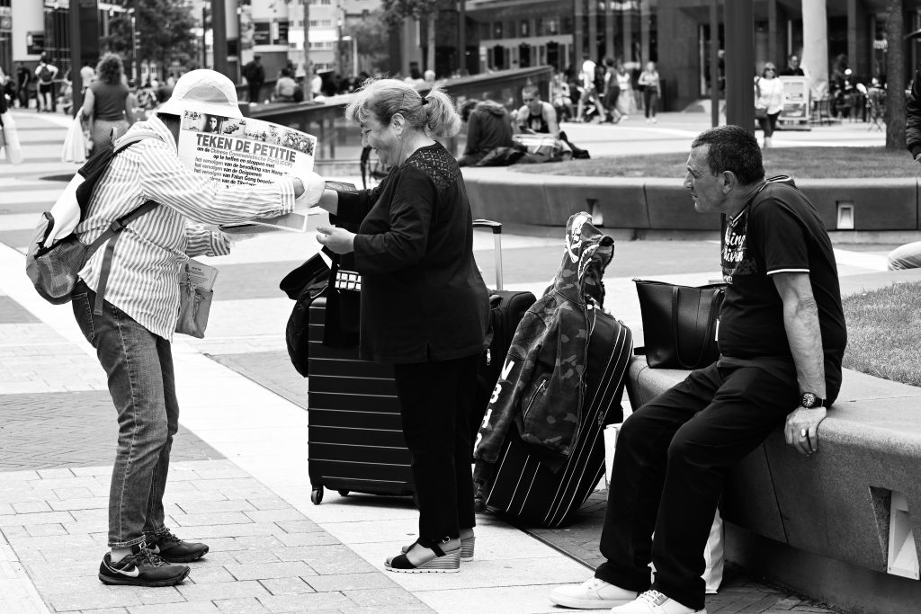 Het stationsplein voor Hoog Catharijne. Een dame staat daar met een petitie om de chinese communistische volkspartij op te heffen