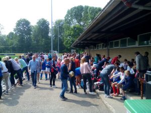 het publiek verzamelt zich voor de kantine in de zon