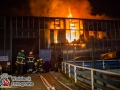 Ein Großfeuer zerstörte Teile einer 2000m² großen Lagerhalle. Die Lagerhalle war mit mehrere Etagen aufgebaut. Es brannten eine Werkstatt und ein Lagerraum vollständig aus. Das Hallendach stürzte teilweise ein. Die Feuerwehr war mit mehr als 70 Rettern im Einsatz. Foto: Dominick Waldeck