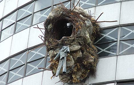 A giant birds nest attached to the side of an office building