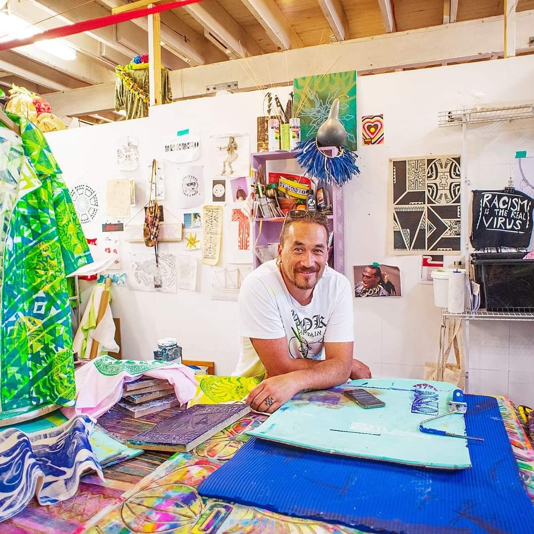 Person leaning against a table full of art materials