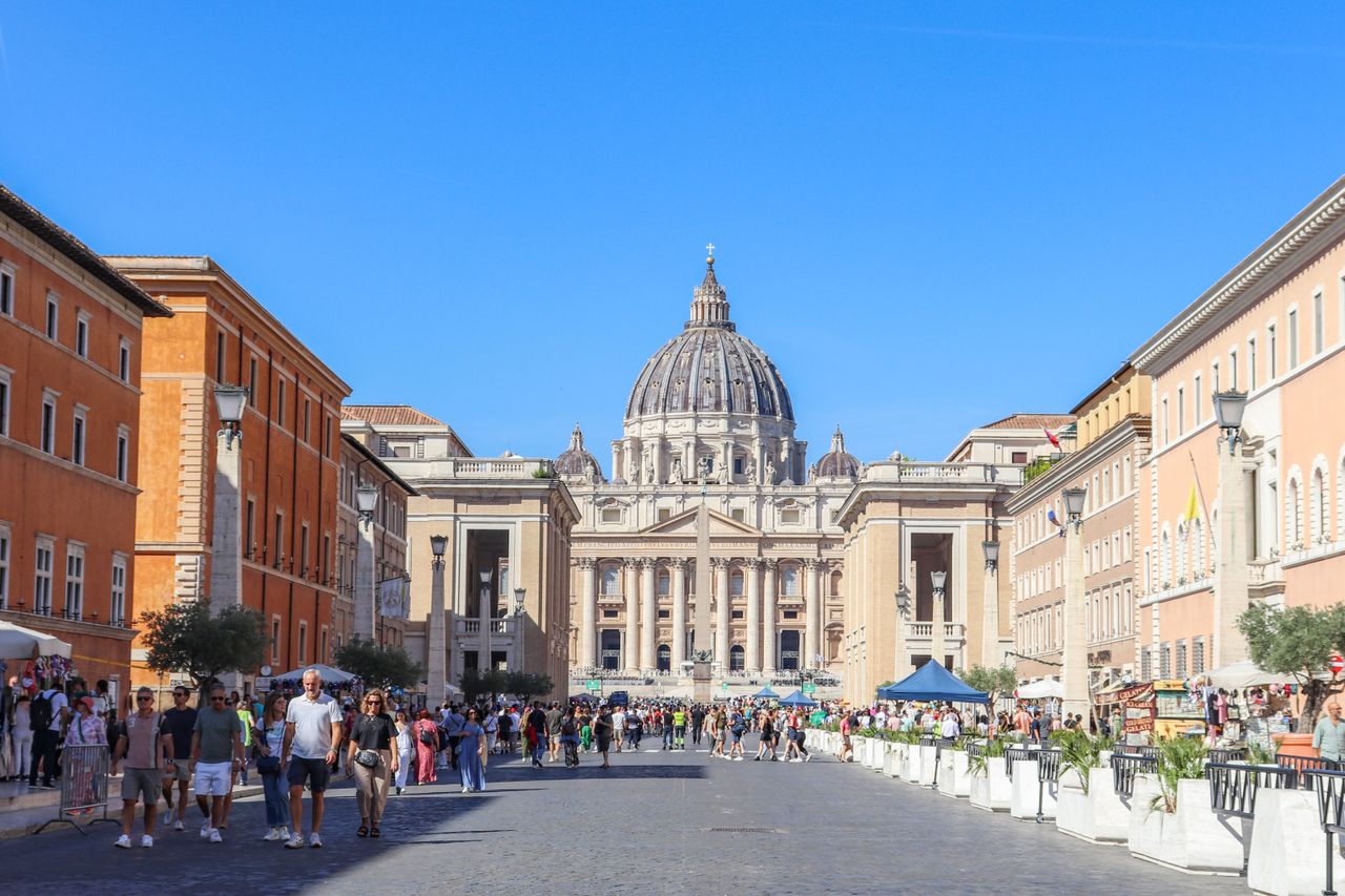 Busy street scene leading to St. Peter's Basilica in Vatican City on a bright and sunny day.
