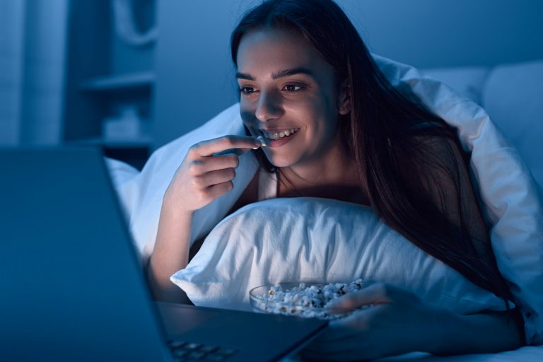 Cheerful female watching film at night