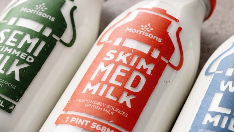 Close-up of redesigned Morrisons milk bottles featuring colour-coded labels for whole, semi-skimmed and skimmed milk.