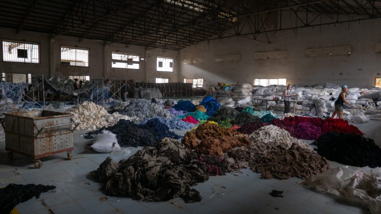 Sorting through hundreds of tons of clothing in an abandoned factory for a social mission called Clothing the Loop.