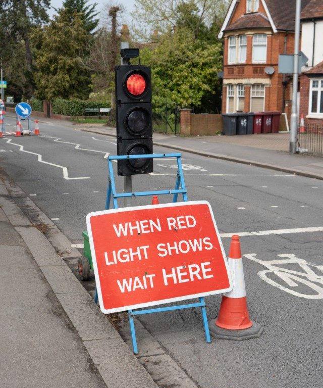 A temporary traffic light at the side of the road.