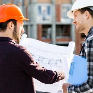 Close up from the back of two engineer-architects supervising construction