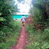 A man approaching a building in the botanical reintegration village for ex-child soldiers in Liberia