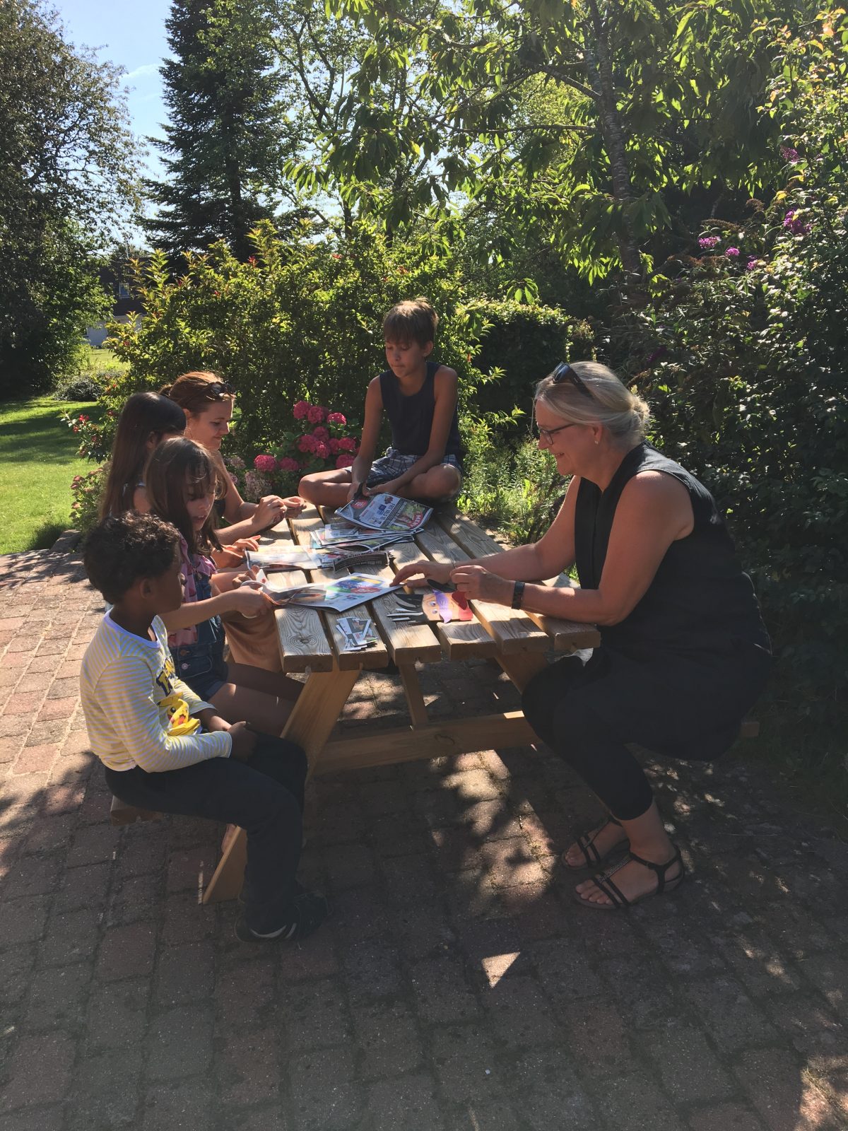 kids and adult sitting at the table outside