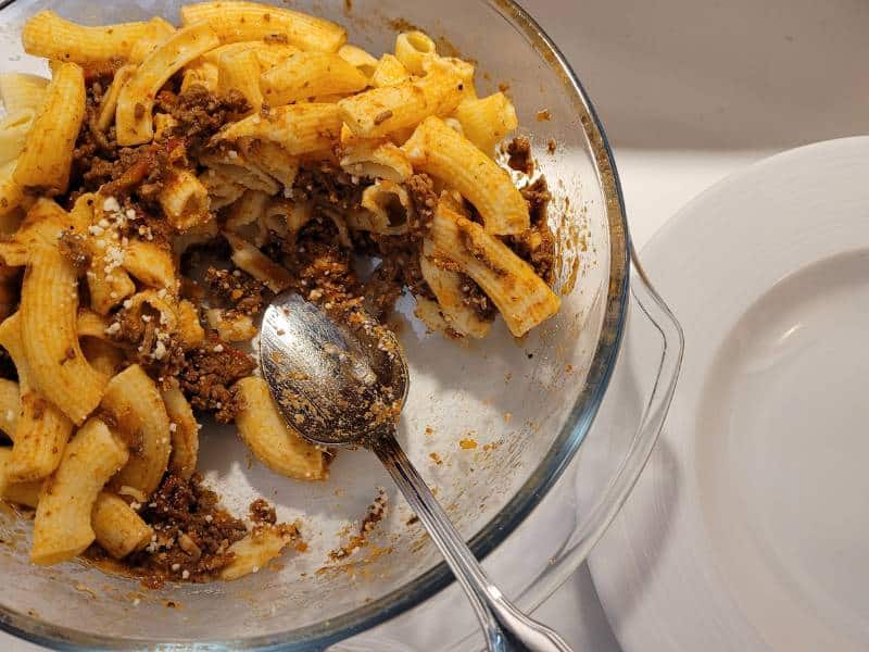 Eine halb volle Schüssel mit Nudeln und Bolognese.