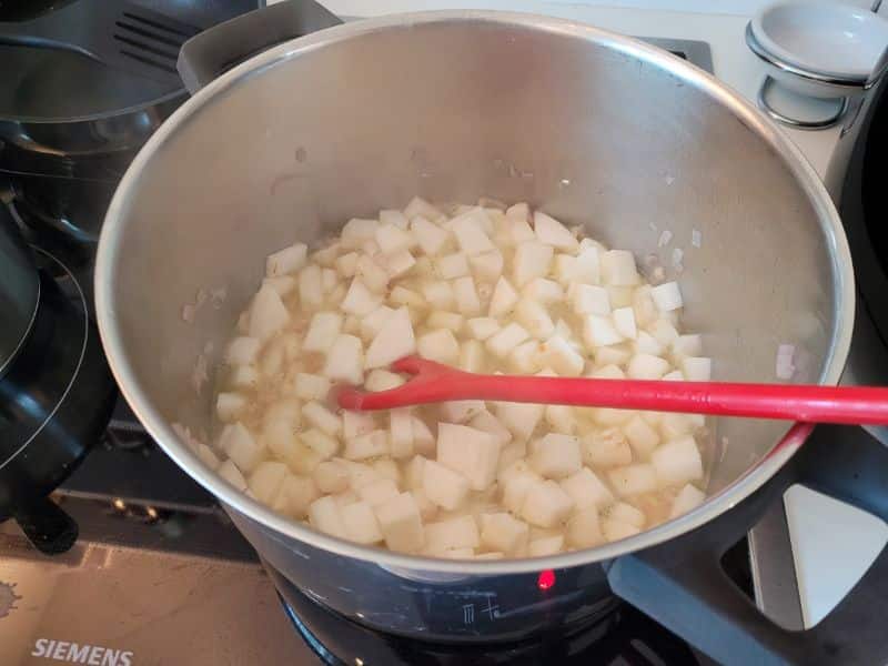 Ein großer Kochtopf mit lauter kleingeschnittenen Mairübchen-Stücken.