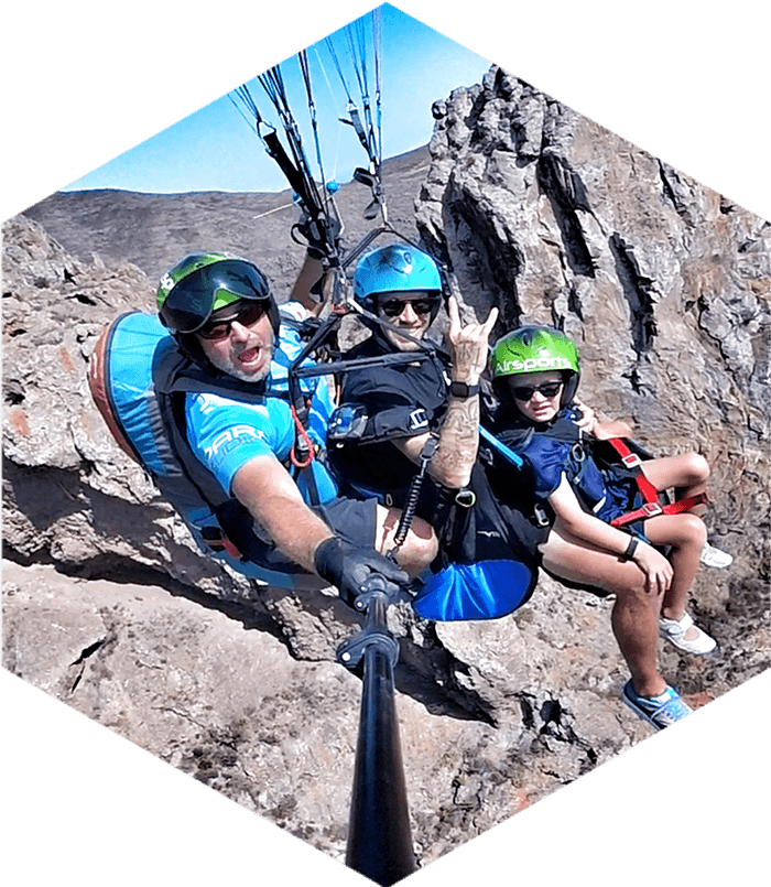 two adults and a child on a paragliding flight
