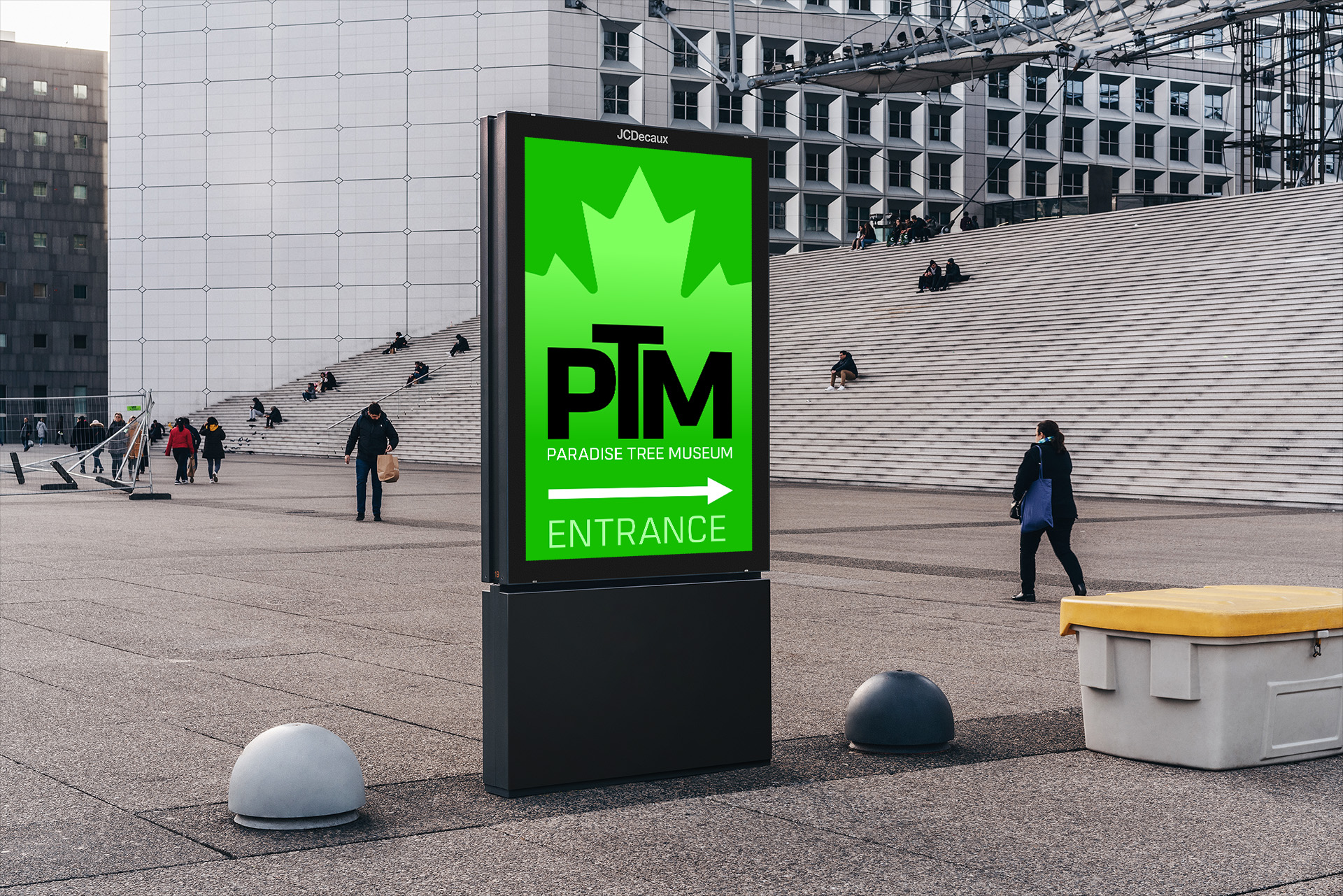 Huge concrete building, sign in front shows direction to the entrance of Paradise Tree Museum