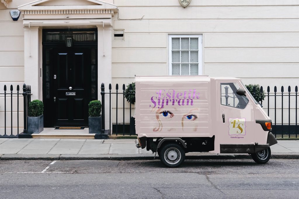 Photo of a Piaggio truck infront of a white building