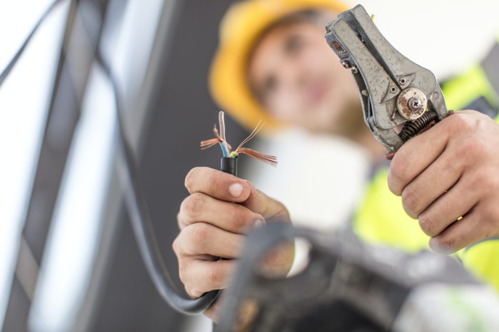 Close-up of electrician working with wire cutter