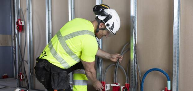 Elektriker från Elinzity drar rör i en vägg