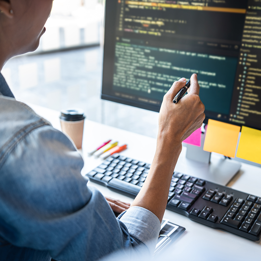 kvinde ser på computer skærm med html kode
