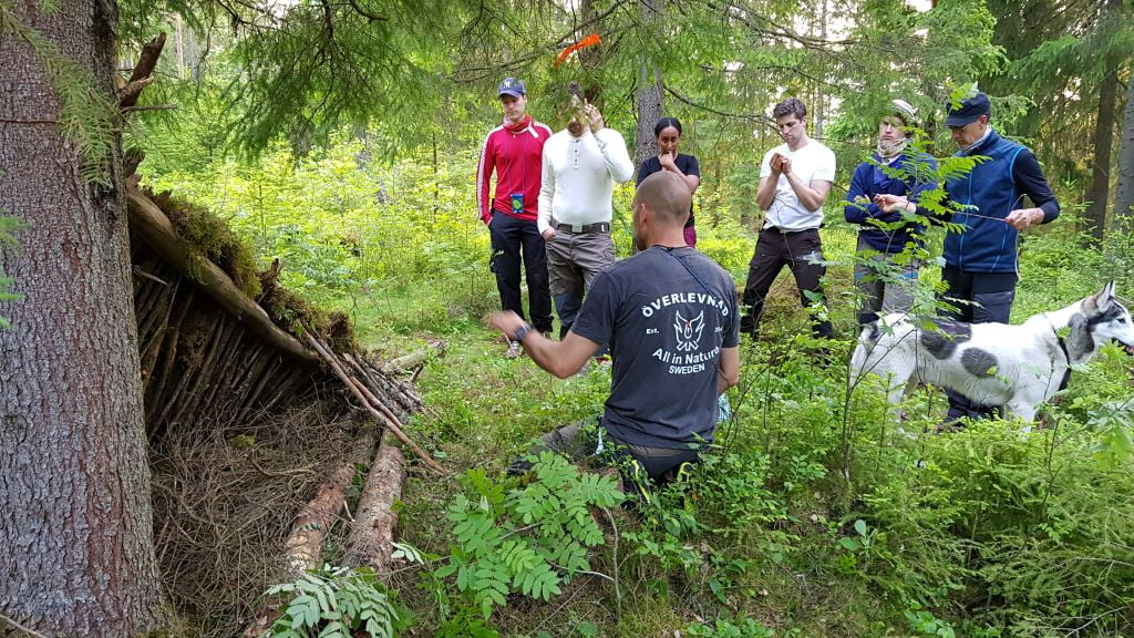 En instruktör förevisar en bivack för en grupp deltagare på kursen Överlevnadsdygn.