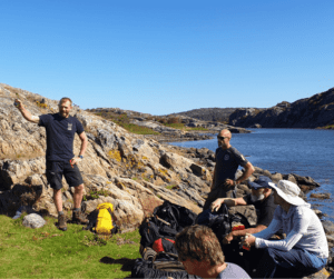 Torbjörn förevisar fiske för en teambuildinggrupp vid havskanten.