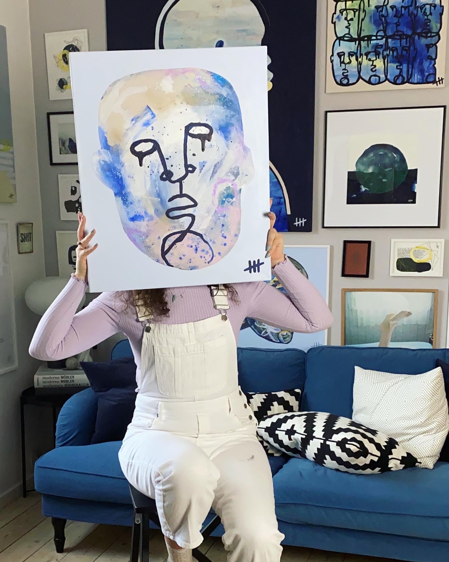 Kunstner som sidder med et af hendes malerier