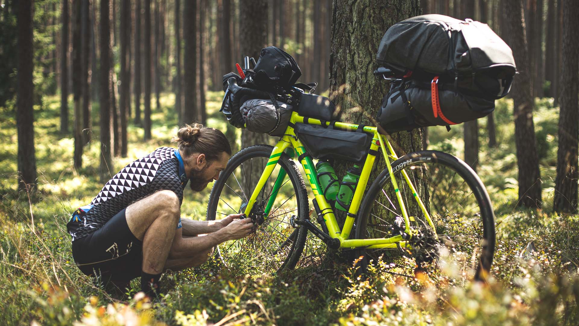 Er du klar for backpacking? Syklist som gjør sykkelen klar for tur i skogen