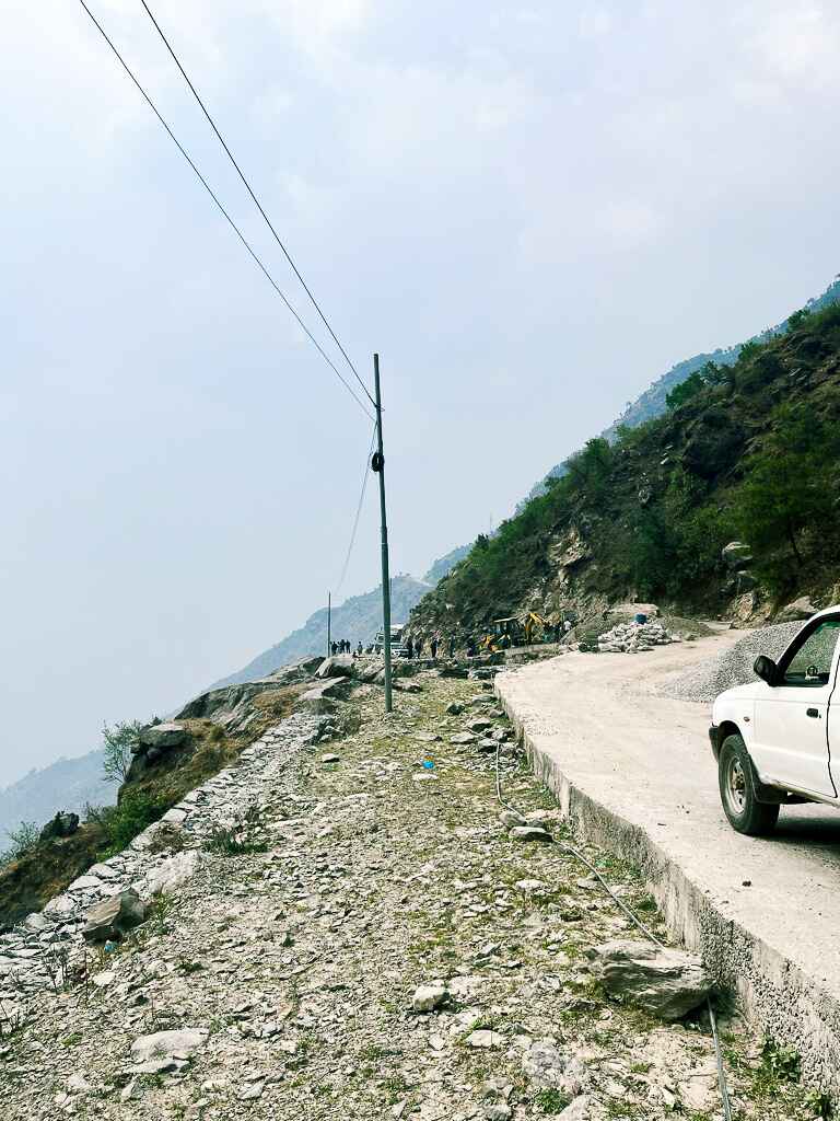 The road to Syabru Besi with a steep ravine to the left and a car to the right