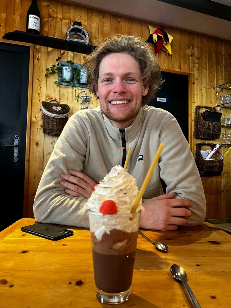 Wessel with a large hot chocolate in Valfréjus, France, ski