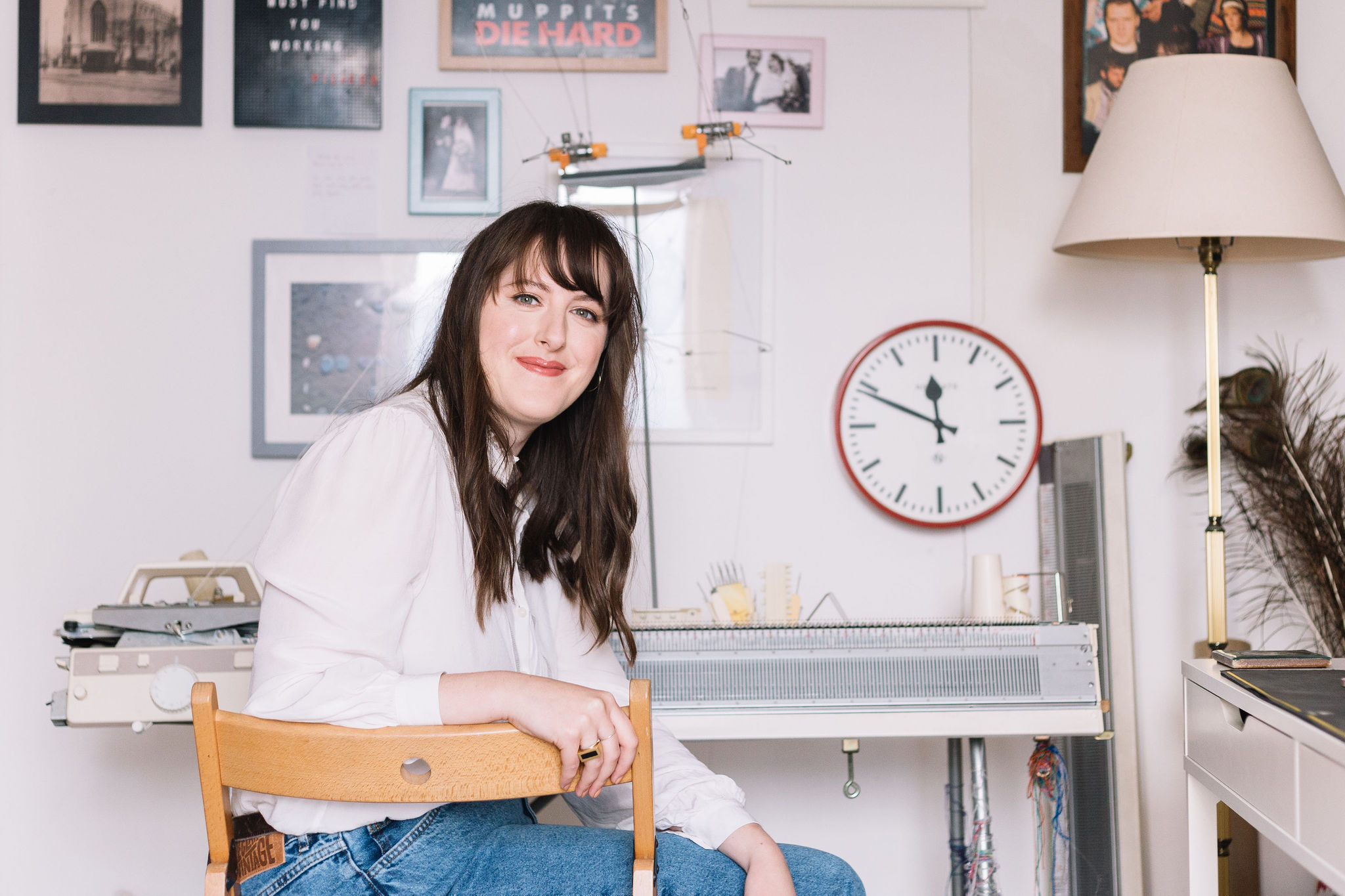 Amber Hards sitting in a chair in front of her knitting machine