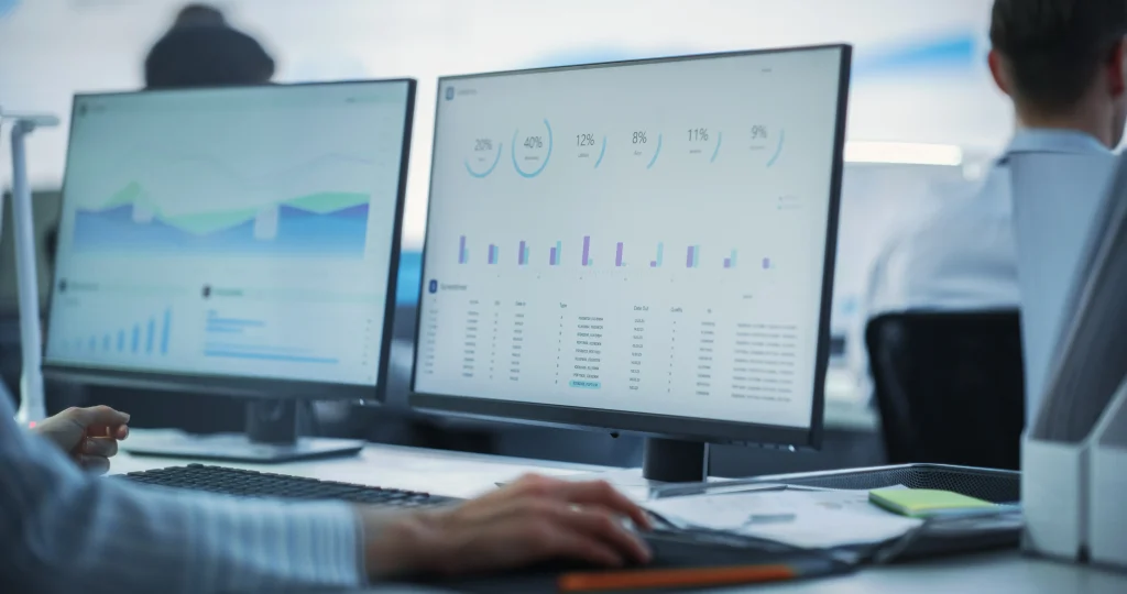 Computer screens showing graphs, data, and spreadsheets