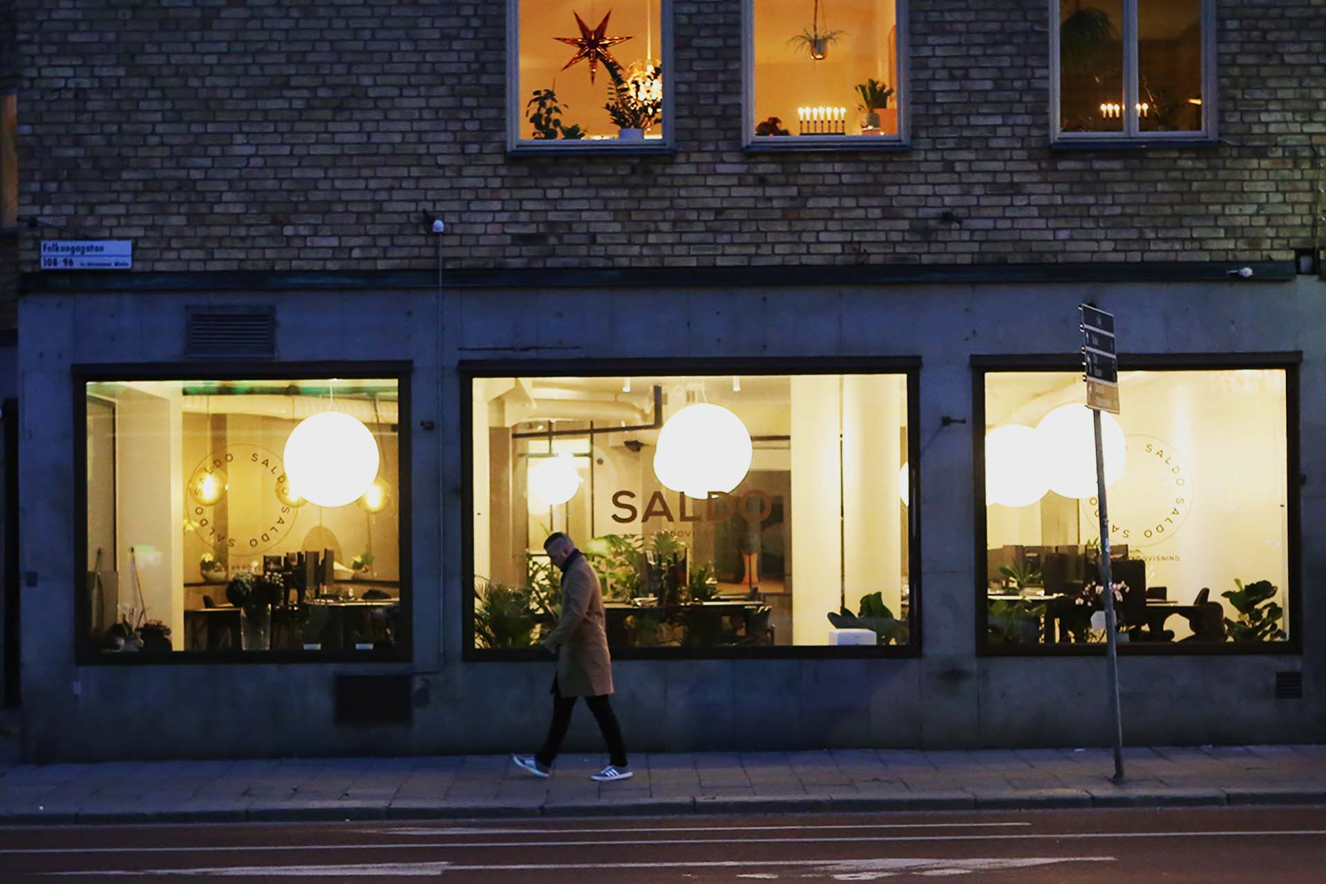 Kontor med industriell känsla i svart, vitt och betong av arkitekt Anders Frelin. Moon-lampor lyser i gatufönstren.