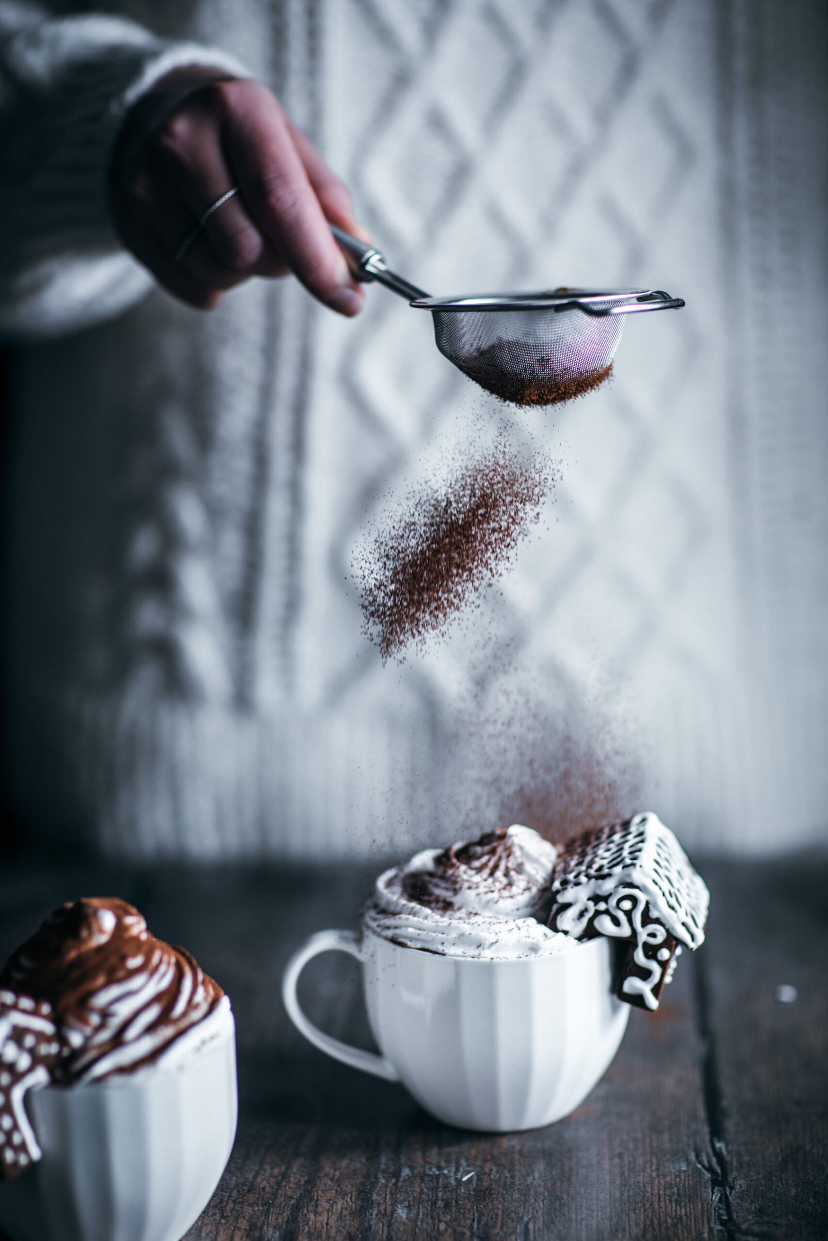 Dusting cocoa powders over hot chocolate with cream