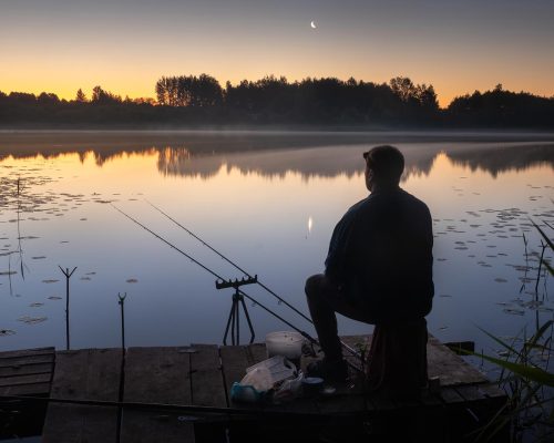 at-night-a-fisherman-sits-on-the-pier-with-fishin-2023-11-27-05-22-18-utc.jpg