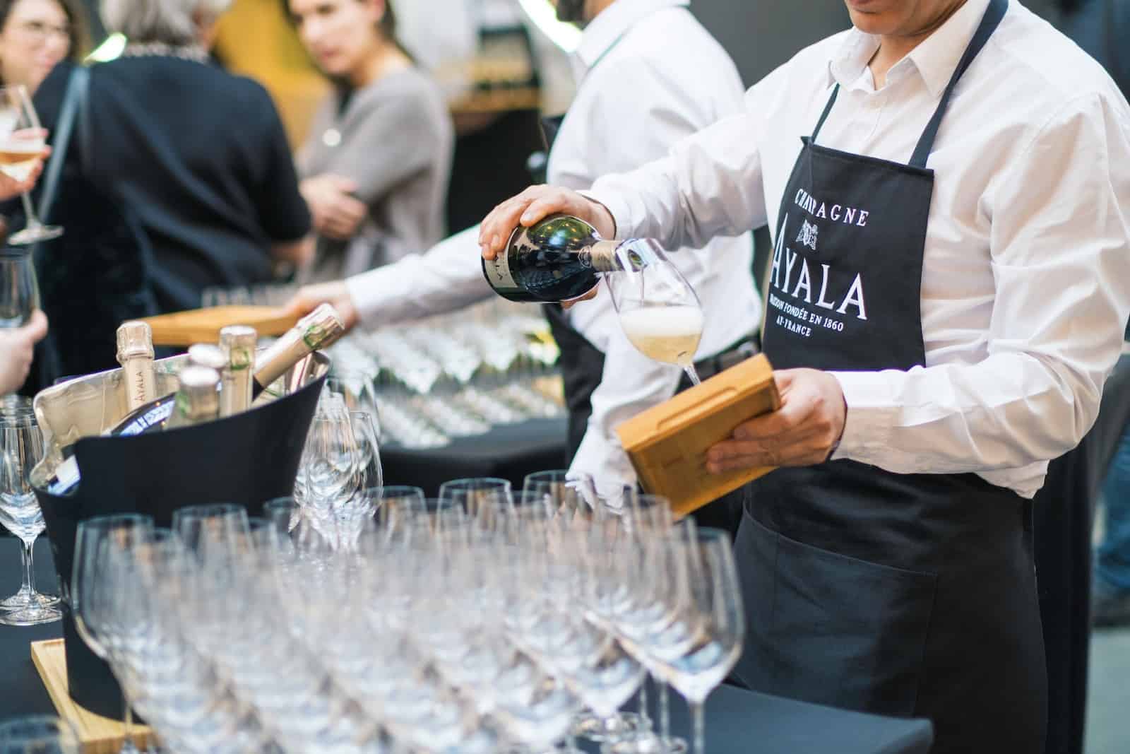 a man pouring a glass of wine at a wine tasting event