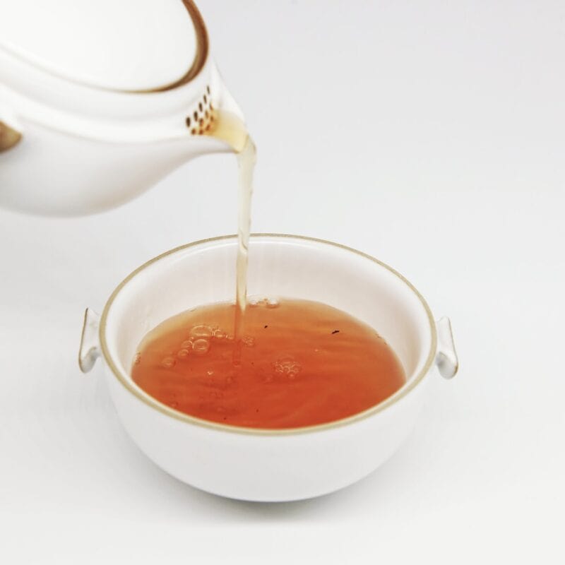 tea pours into white teacup