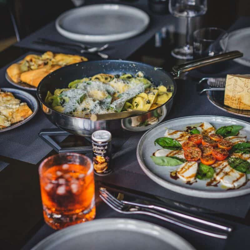 a table with plates of food and glasses of beer