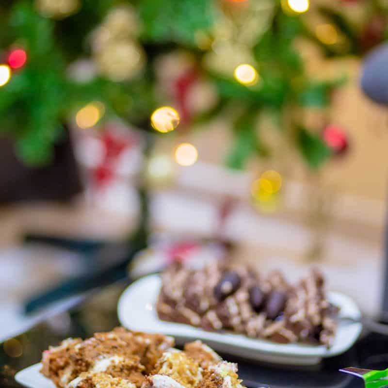 a table topped with plates of food next to a christmas tree