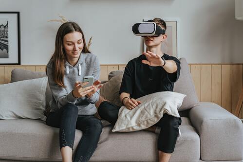 En tjej med mobil och och en kille med VR-glasögon prövar tekniken