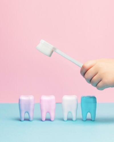 Child's hands holding big tooth and toothbrush