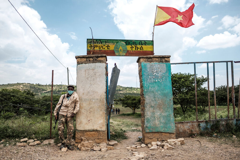 Left: An armed member of the community security force stands in front of a school where a polling station is located during Tigray’s regional elections, in Tikul, Ethiopia, on Sept. 9. EDUARDO SOTERAS/AFP via Getty Images Right: Ethiopians, who fled their homes due to ongoing fighting, are pictured at a refugee camp in the Hamdait border area of Sudan’s eastern Kassala state on Nov. 12. AFP via Getty Images