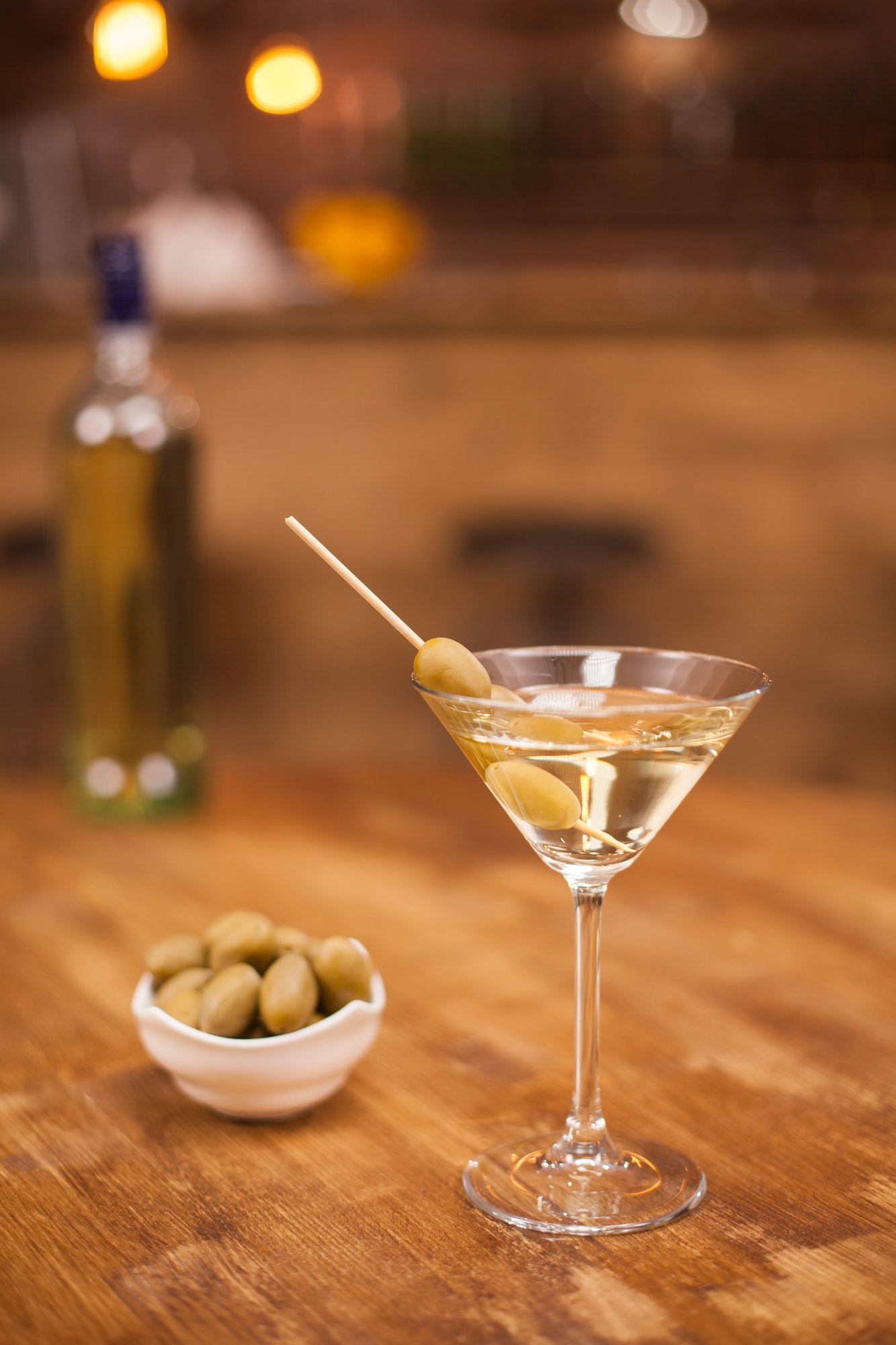 Celebration with a glass of white martini and olives in a restaurant at the bar counter