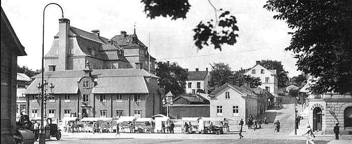 Samma sida av Stora Torget i Södertälje förr. Byggnaden som anas längst till höger är samma som syns till höger i den nutida bilden.