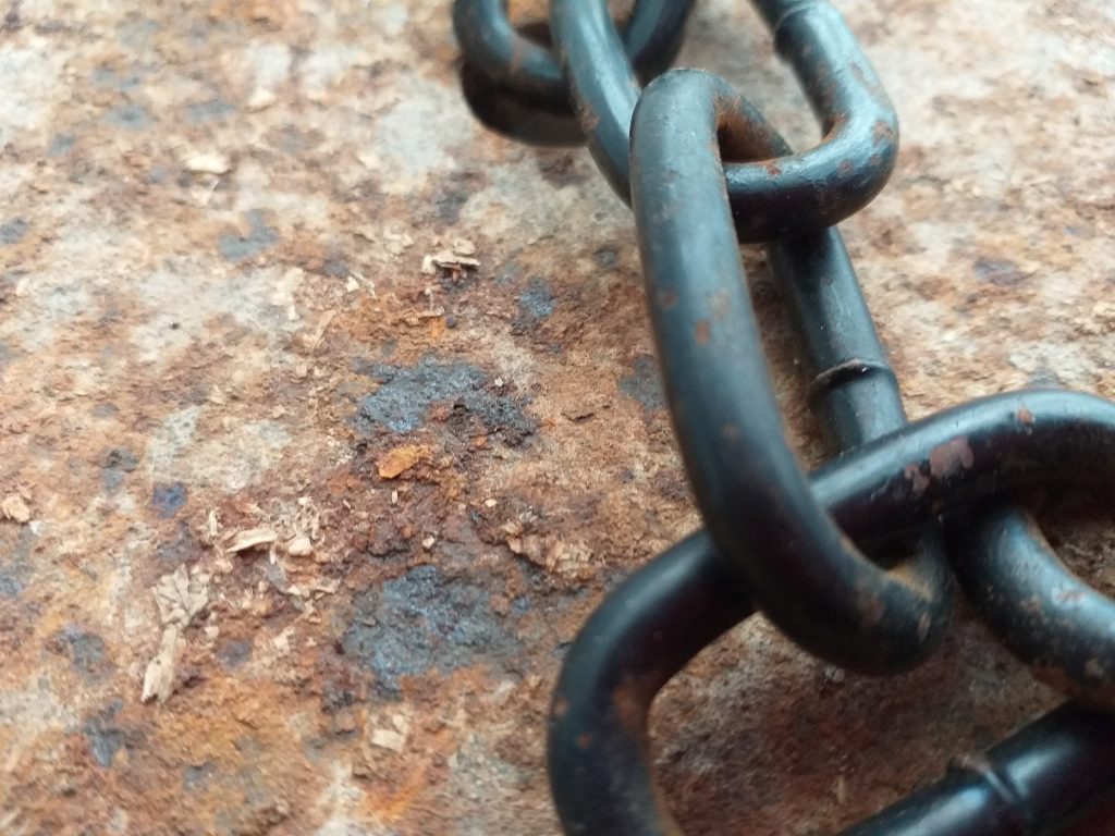 Rusty piece of metal and scrap of chain  'vibrant, calling, bristling' join together in a way that calls out 'Prometheus!'