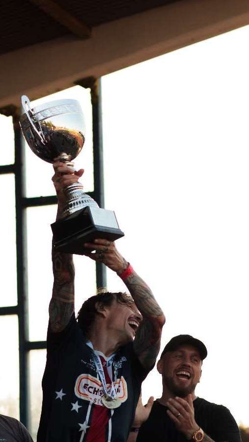 Justin Hawkins raises his trophy in triumph after winning the tournament