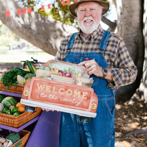 a bearded man smiling while standing near the cart with woven baskets