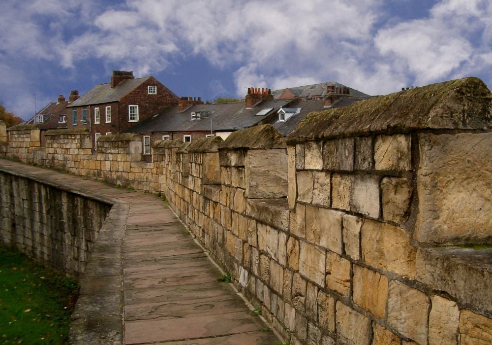 An ancient stone wall stretching through the town of York, England