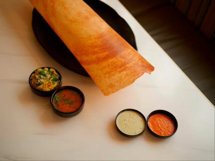 A dosa and four dips on a table at Woodlands