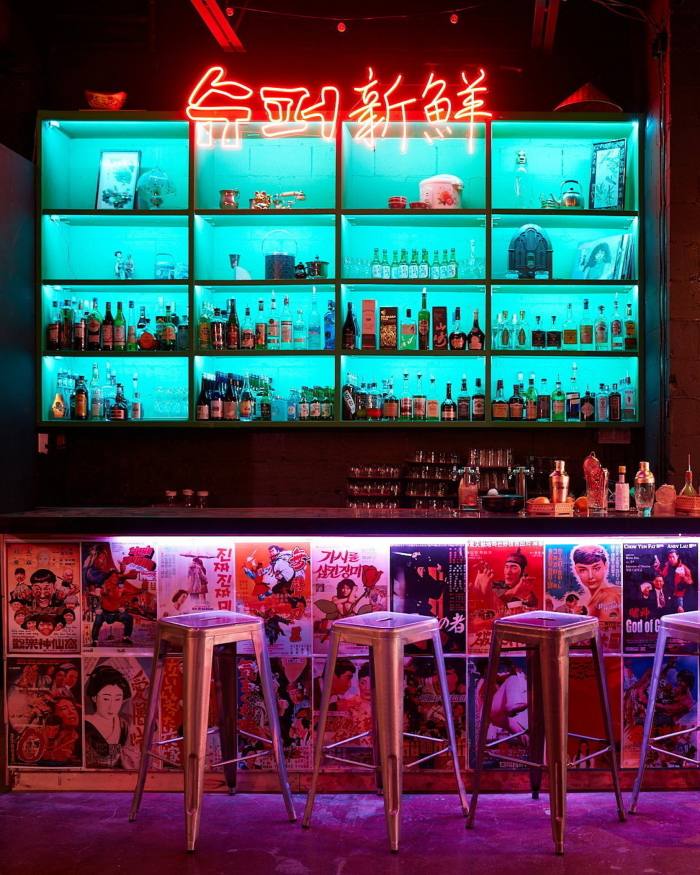 Neon shelving and a neon sign behind the counter of Bar Superfresh