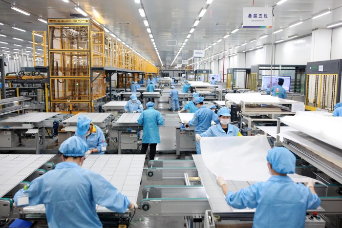 Employees work on photovoltaic panels at a factory in Ningbo, Zhejiang province
