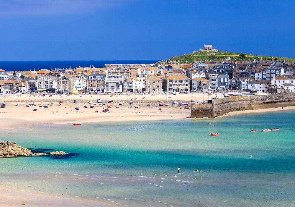 st ives beaches in cornwall with buildings, people and boats