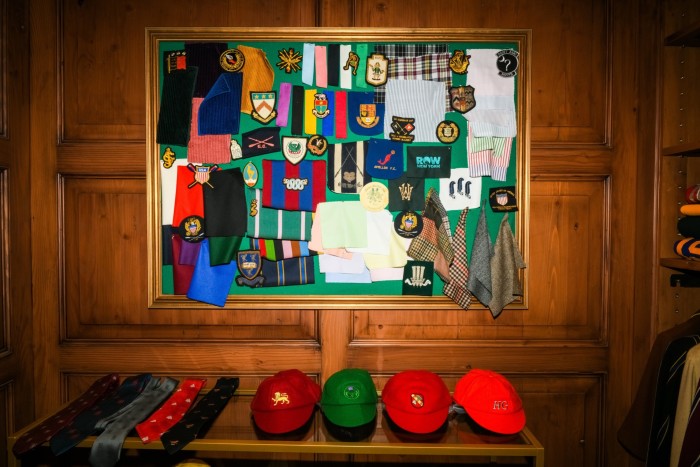 caps and badges displayed on a wooden shelf and on a board on a wooden wall